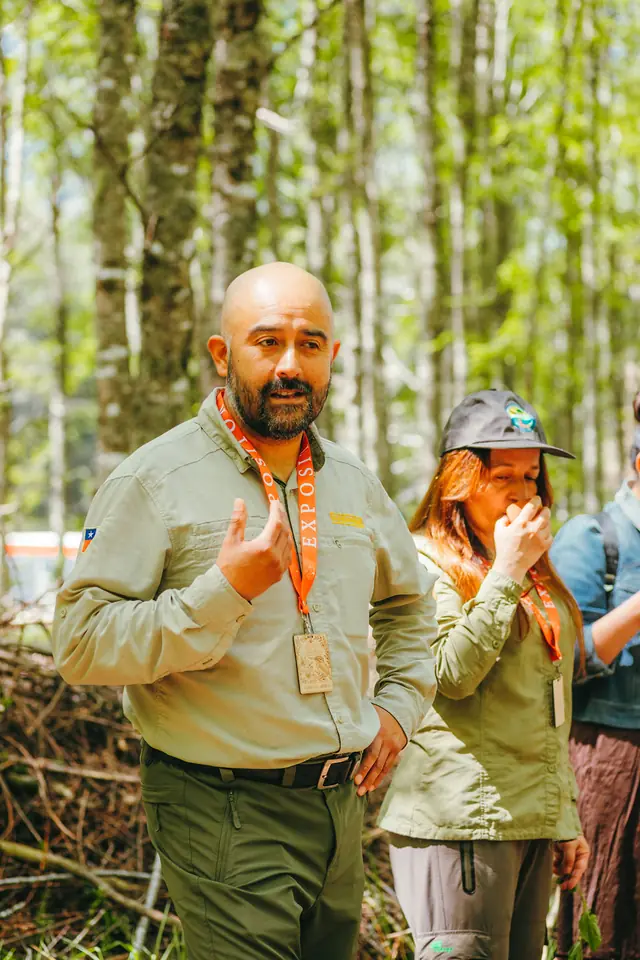 Guía conversa con visitantes en el bosque