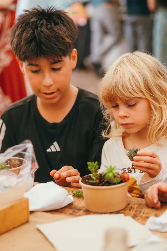 Niño y niña plantando en un taller